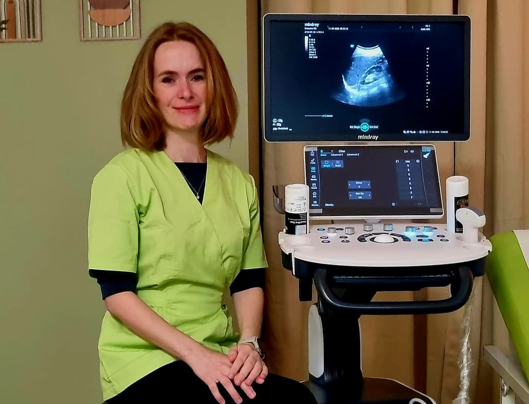Dr. Gabriela Negrean, medic gastroenterolog, lângă ecograful din cabinetul său din Zalău; pe ecran, o imagine de ecografie abdominală.